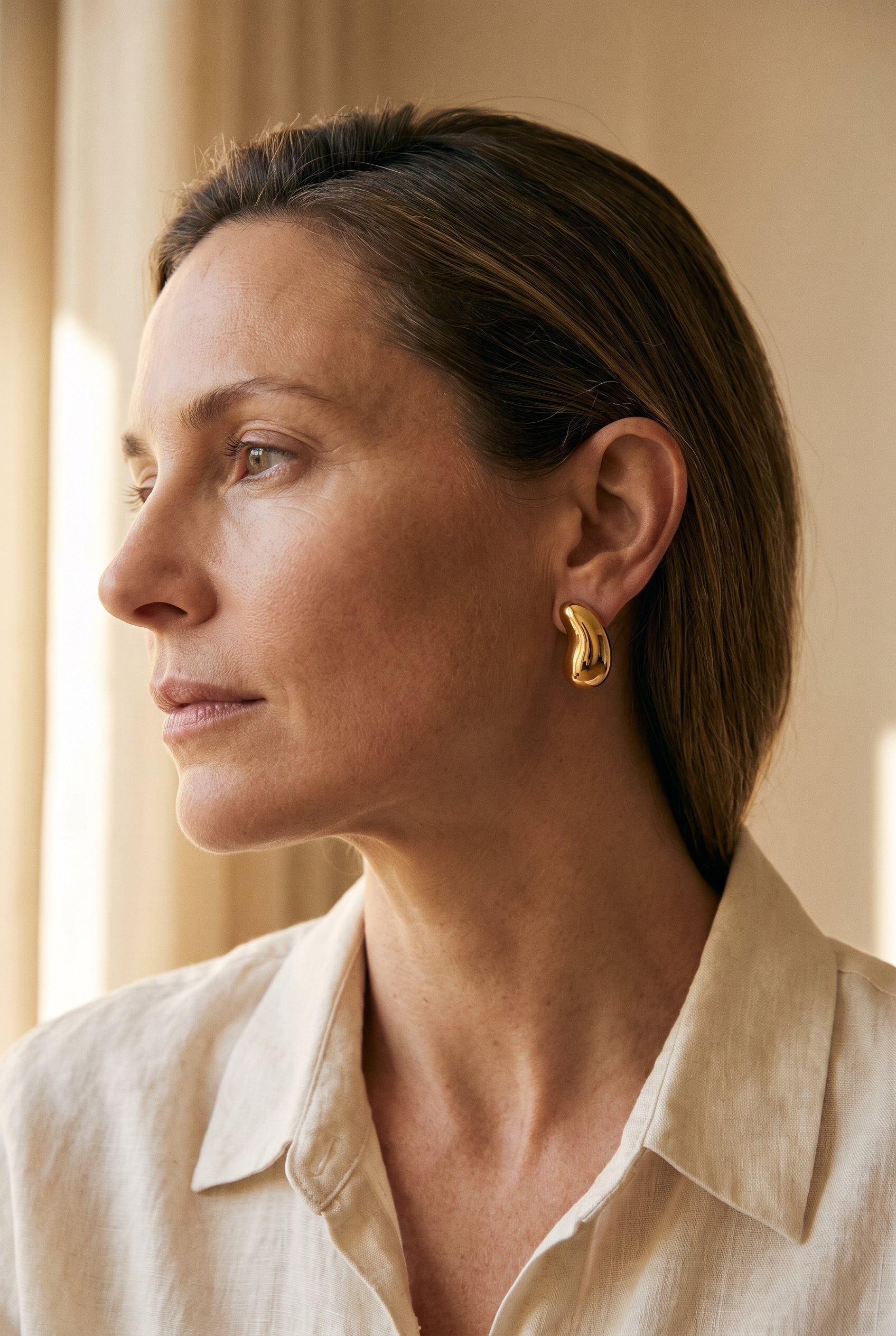 Tiffany & Co. Elsa Peretti Yellow Gold Bean Clipback Earrings — shown worn