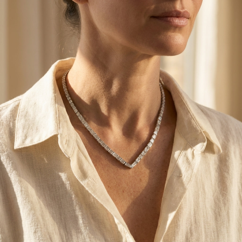 Platinum diamond riviera necklace worn at an open linen collar, editorial lifestyle photo