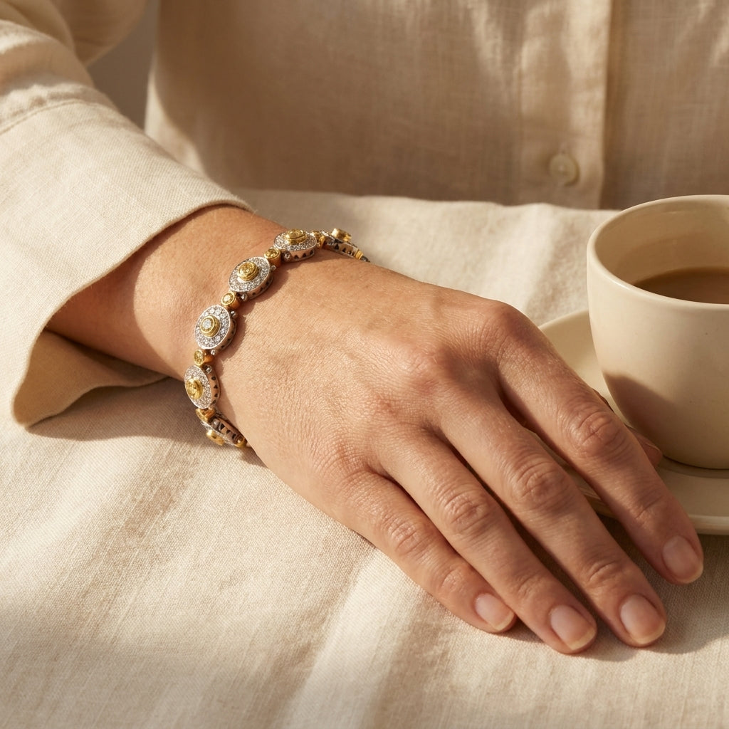 Yellow diamond oval link bracelet worn on a wrist resting on linen, editorial lifestyle photo